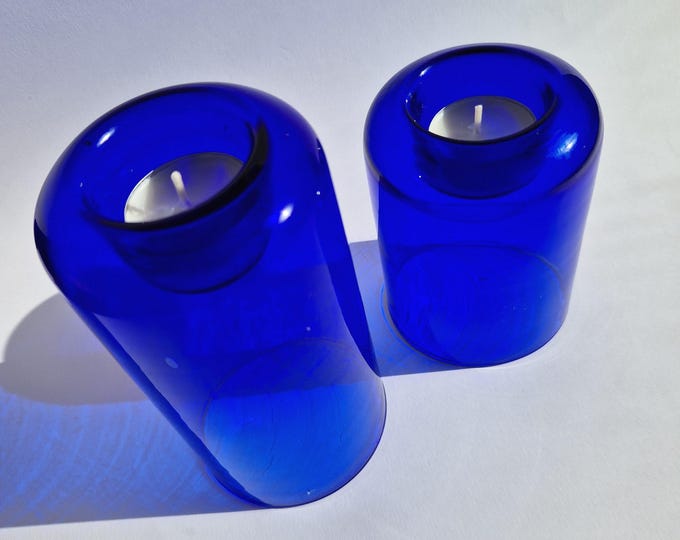 Pair of Dark Blue Glass Tealight Holders. One Higher than the Other. Simple Modern Shape. Stylish Scandinavian Glass Home Decoration.