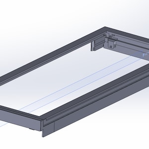 May include: A gray rectangular frame with a clear, rectangular interior. The frame has a raised edge and a small mechanical component on one side. The design appears to be a 3D rendering or technical drawing.