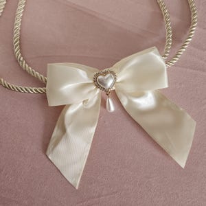 フィリピン系およびヒスパニック系カトリックの結婚式のためのハート型ウェディングユニティコードラッソ付きアイボリーサテンリボンボウ