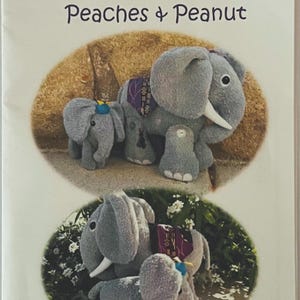 May include: A product package for "Dinky Baby" cloth doll patterns. The package features two images of gray elephant dolls with white tusks and decorative saddle blankets. The text "Peaches & Peanut" is displayed.