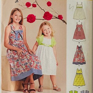May include: Simplicity easy-to-sew pattern 8064 for girls' dresses. The pattern includes multiple dress styles, with illustrations of the finished garments. The cover features two girls and the text "easy-to-sew".