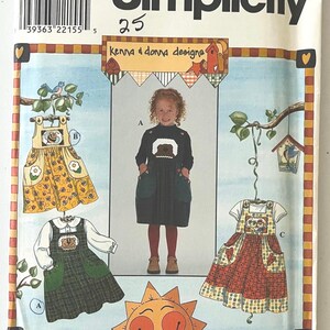 Puede incluir: Patrón de costura Simplicity 8389 para vestidos de niña. El patrón presenta tres diseños de vestidos con detalles de osos y flores. La portada incluye el texto "Kenna & Donna Designs" y la talla "5,6,7,8".