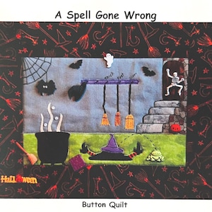 Könnte beinhalten: Ein Halloween-Button-Quilt mit dem Text "A Spell Gone Wrong". Der Quilt zeigt einen Kessel, einen Hexenhut, Besen und ein Skelett. Der Rand ist schwarz mit Hexenhüten und Besen.