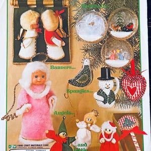 Może przedstawiać: Vintage arkusz wzorów świątecznych z różnymi ozdobami i dekoracjami świątecznymi. Arkusz zawiera obrazy aniołów, bałwanów i ozdób w kształcie serca. Tekst "Christmas Is..." znajduje się na górze, z "Banners...", "Spangles...", "Angels..." i "and Little Surprises" poniżej.