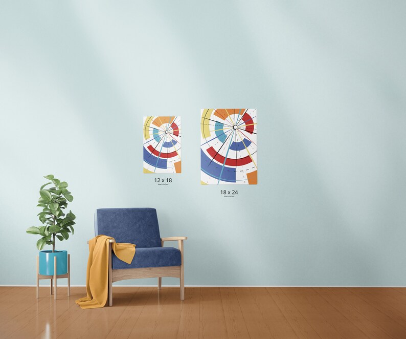 May include: Two abstract art prints with a circular design in shades of red, blue, yellow, and orange are displayed on a light blue wall. The prints are labeled 12 x 18 inches and 18 x 24 inches. A blue armchair and a potted plant are in the foreground.