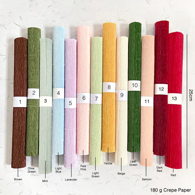 May include: A collection of thirteen rolls of 180 g crepe paper in various colors, including brown, olive green, mint, light blue, lavender, pale pink, light green, yellow, beige, leaf green, salmon, dark red, and red. The rolls are approximately 25cm tall.