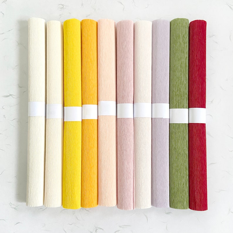 Peut inclure: Plusieurs rouleaux de papier cr&eacute;pon de couleurs vari&eacute;es : cr&egrave;me, jaune, p&ecirc;che, lavande, vert et bordeaux. Chaque rouleau est maintenu par une bande blanche. Le papier pr&eacute;sente une surface textur&eacute;e, id&eacute;al pour les loisirs cr&eacute;atifs.