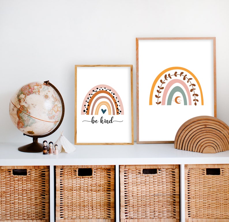 K&ouml;nnte beinhalten: Zwei gerahmte Drucke von Regenbogenillustrationen. Der Druck links hat einen rosa, orange, gelben und braunen Regenbogen mit schwarzen Punkten und dem Text "be kind". Der Druck rechts hat einen rosa, blauen und gr&uuml;nen Regenbogen mit braunen Ranken.