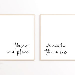 May include: Two framed prints with black calligraphy on a white background. The left print says "This is our place" and the right print says "We make the rules".