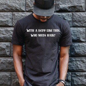May include: A black t-shirt with the text "WITH A BODY LIKE THIS, WHO NEEDS HAIR?" printed in white.
