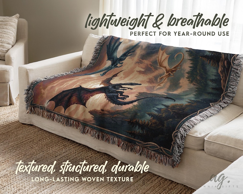 May include: A woven throw blanket featuring a fantasy scene with dragons in flight. The blanket has a detailed illustration in shades of blue, brown, and orange. The text "lightweight & breathable" and "textured, structured, durable" is visible.