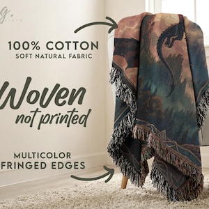 May include: A woven cotton throw blanket with a fantasy dragon scene in shades of blue, green, and brown. The blanket has fringed edges and the text "100% Cotton Soft Natural Fabric" and "Woven not printed" is visible.