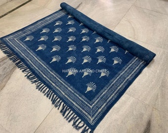 Puede incluir: Una alfombra de algodón azul con un patrón floral blanco y flecos. La alfombra está enrollada y tiene el texto "HARMAN ART AND CRAFT" impreso en ella.