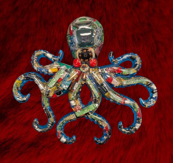 An octopus sculpture hand-built from real recycled circuit boards and motherboard scraps, with glow-in-the-dark resin — e-waste turned into genuine wall art that hits the intersection of tech and sea creature obsession perfectly.