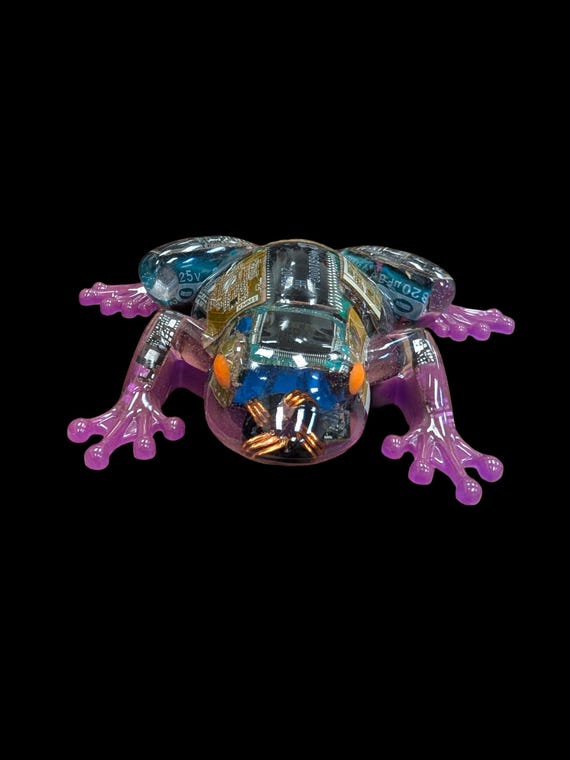 A tree frog sculpted from actual recycled circuit boards and e-waste, finished in UV-reactive resin that glows under blacklight — genuinely one-of-a-kind techie art.