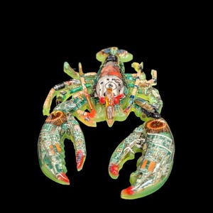 May include: A lobster-shaped sculpture crafted from translucent light green resin, embedded with various electronic components including green circuit boards, copper coils, resistors, and metallic parts, featuring red accents on the claws and head.