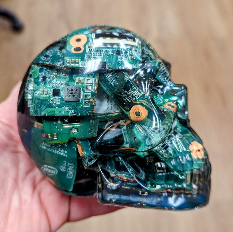 May include: A clear resin skull filled with green circuit boards. The skull is a decorative object and is a unique piece of art.