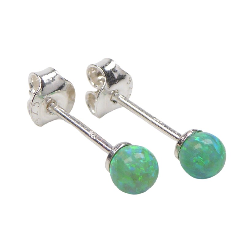 May include: A pair of silver stud earrings with green opal stones.