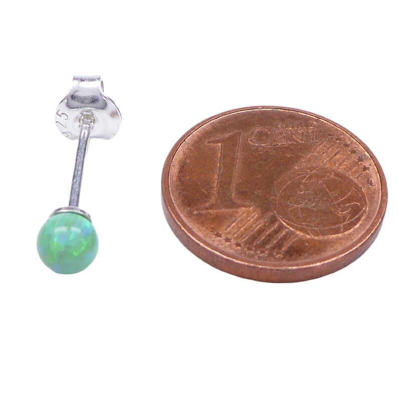 May include: A single green opal stud earring with a silver post and butterfly back. The earring is shown next to a 1 cent Euro coin for size comparison.