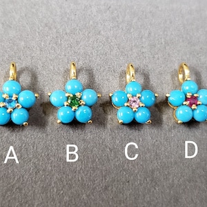 May include: Four gold flower charms with turquoise stones and different colored center stones. The charms are labeled A, B, C, and D.