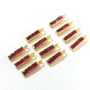 以下が含まれることがあります： 赤い宝石のアクセントが付いた金色のチャームが10個。各チャームは、5つの正方形の宝石が付いた長方形のバーです。