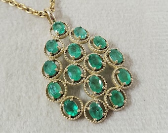 May include: A gold necklace with a pendant featuring a cluster of emerald green gemstones set in gold.
