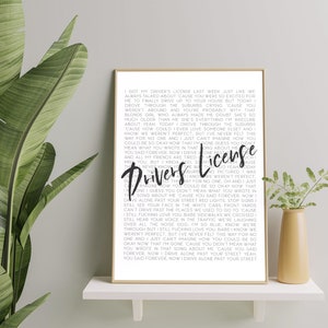 May include: A black and white printable wall art print featuring the lyrics to the song "Drivers License" by Olivia Rodrigo. The lyrics are printed in a simple font and are centered on the page. The title of the song is printed in a larger font and is centered at the top of the page.