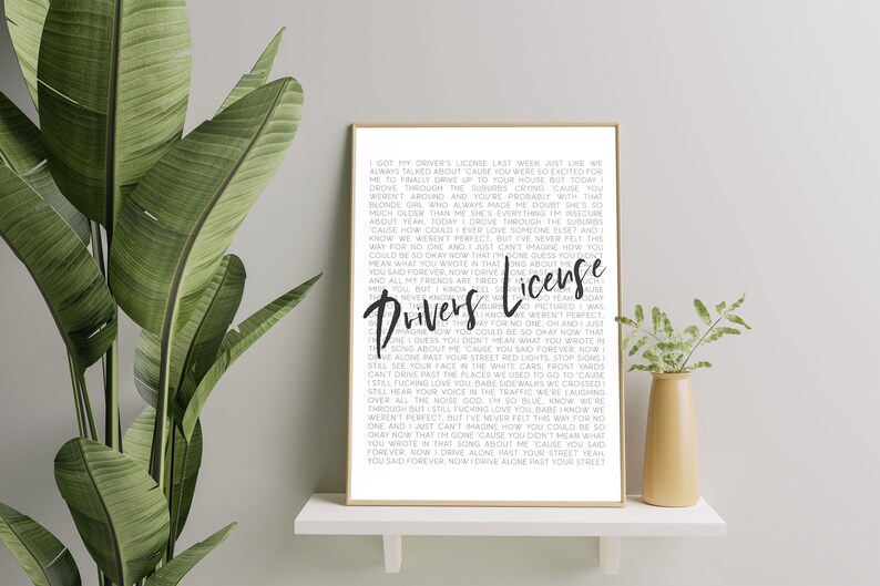 May include: A black and white printable wall art print featuring the lyrics to the song "Drivers License" by Olivia Rodrigo. The lyrics are printed in a simple font and are centered on the page. The title of the song is printed in a larger font and is centered at the top of the page.