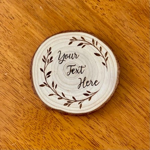 May include: A round wooden slice with a decorative floral design burned into the surface. The text "Your Text Here" is centered within the design.