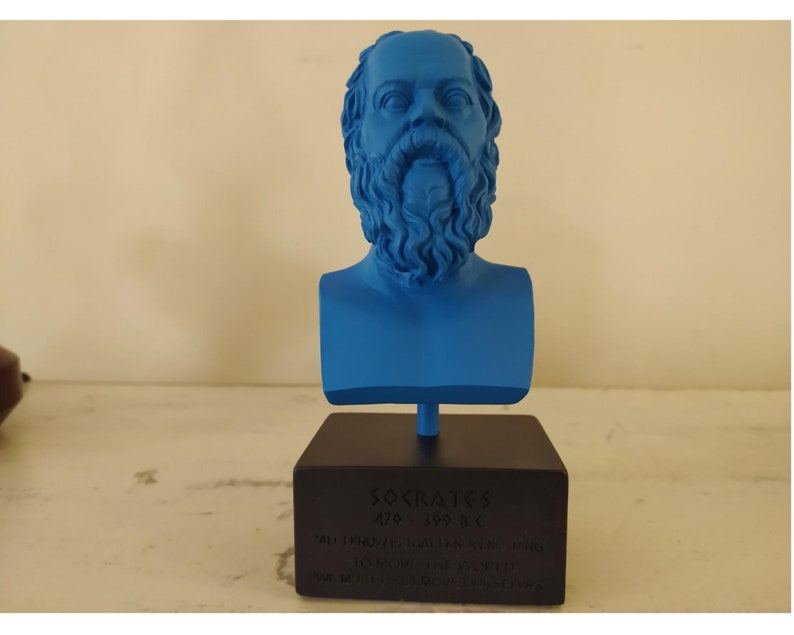 May include: A blue 3D printed bust of Socrates on a black base with the inscription "SOCRATES 470 - 399 BC" and a quote in Greek.