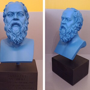 May include: A blue bust sculpture of Socrates on a black base. The base has the inscription "Socrates 470-399 B.C. " in Greek letters.