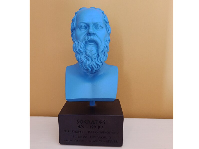 May include: A blue bust sculpture of Socrates, a Greek philosopher, on a black base. The base has the text "SOCRATES 470-399 B.C. "ALL I KNOW IS THAT I KNOW NOTHING" "I AM THE WORLD" - WHICH MOST WISE OBSERVES"