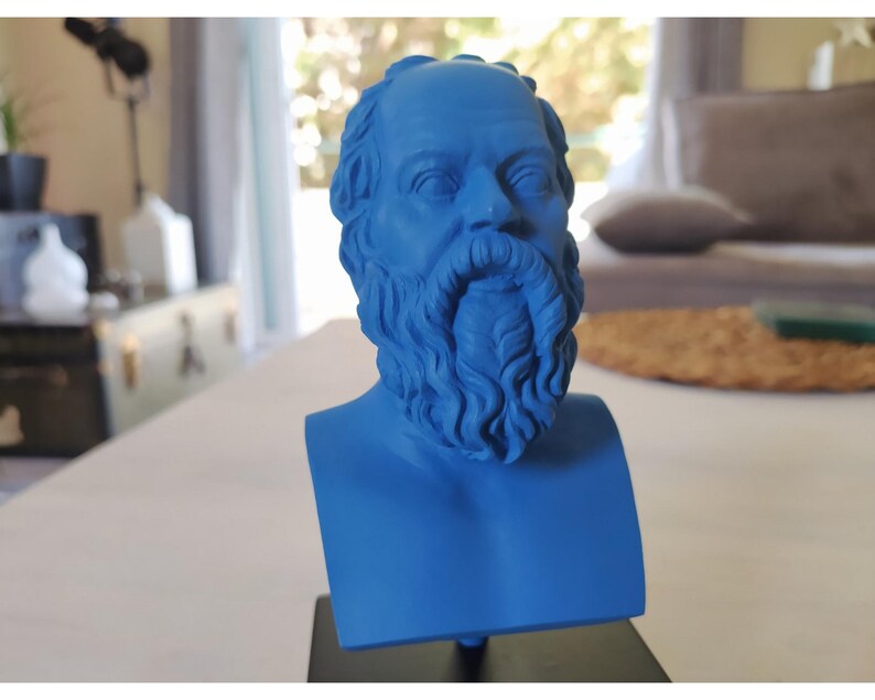May include: A blue 3D printed bust of a man with a beard. The bust is on a black base.