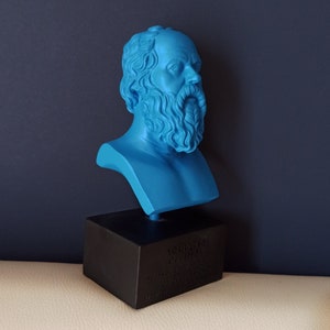 May include: A blue bust sculpture of Socrates on a black base. The base has text that reads "Socrates 470-399 BC Athenian Philosopher".