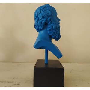 May include: A blue bust sculpture of a man with a beard, on a black base.