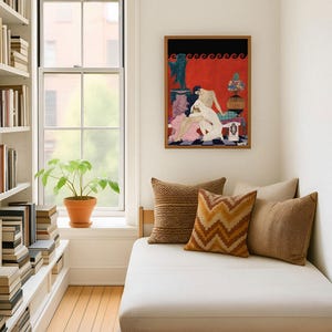 Framed George Barbier erotic illustration decorates a reading nook with large windows and neutral-toned cushions. The bold red and black Art Deco print offers an intimate glimpse into 1920s French fashion art, infusing the space with vintage romance and visual drama.