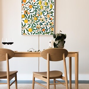 Puede incluir: Dos sillas de madera con respaldos ovalados y una mesa rectangular de madera con una impresi&oacute;n enmarcada en blanco de un patr&oacute;n floral con limones y naranjas colgando de las ramas. Las sillas y la mesa est&aacute;n sobre una alfombra rayada de color marr&oacute;n claro y blanco.