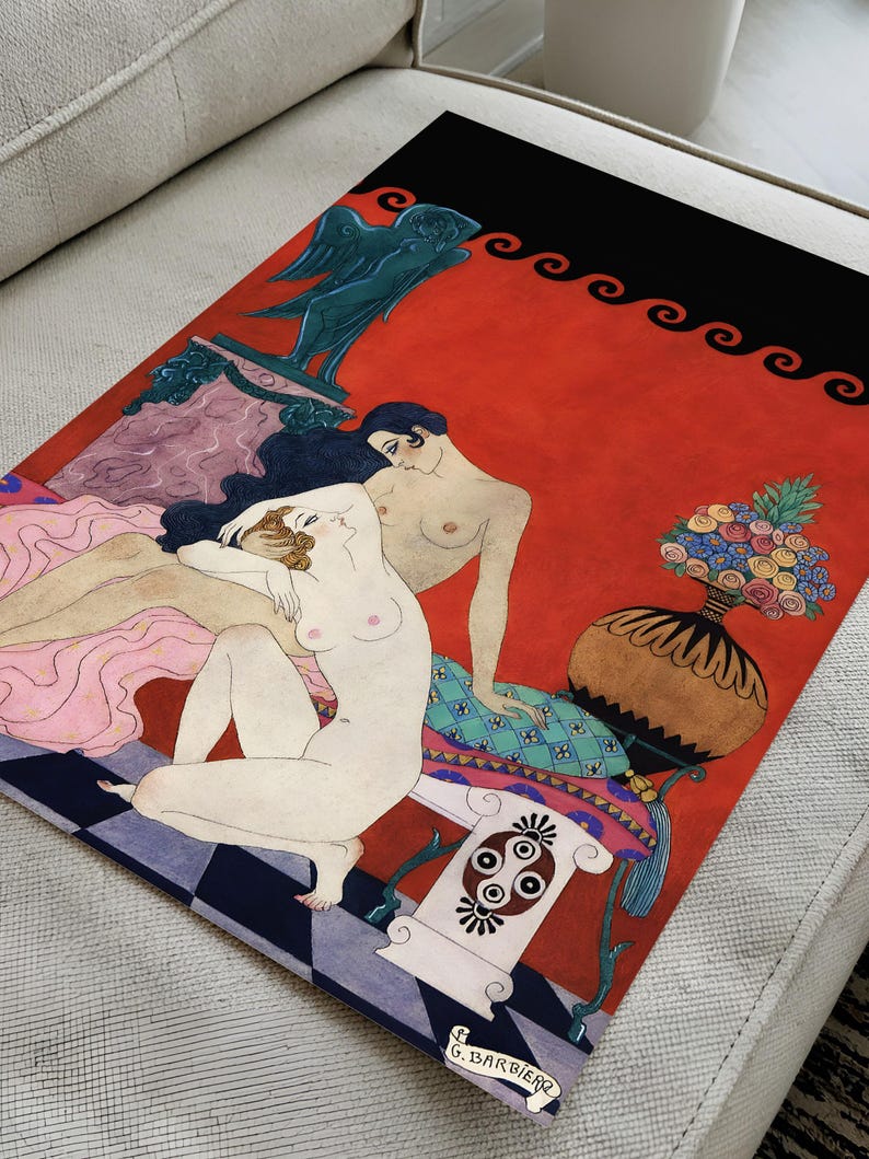 Close-up view of George Barbier’s 1920s Art Deco illustration showing rich details of the nude figures, intricate patterns, and signature. Set on a textured couch surface, the image highlights the quality of the giclée print and the ornate, vintage aesthetic of the artwork.