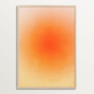 Puede incluir: Impresión artística abstracta con un degradado de color. La obra de arte pasa de un rosa suave en la parte superior a un naranja vibrante en el centro, desvaneciéndose en un amarillo cálido en la parte inferior. La pieza está enmarcada en madera clara.