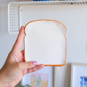 Mini Toast Plate. This is the small version of toast plate. It is exactly the same design but smaller. This plate looks like toast bread slice. Edges are slightly curved upward. This plate is part of the Bakery Collection.