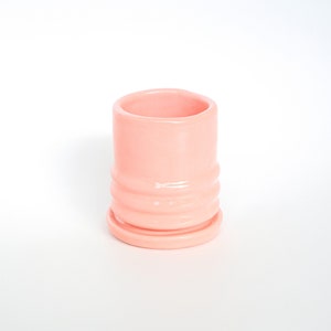Puede incluir: Una maceta de cer&aacute;mica rosa p&aacute;lido con un dise&ntilde;o acanalado y un platillo a juego. La maceta est&aacute; vac&iacute;a.