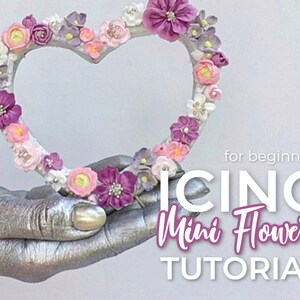 K&ouml;nnte beinhalten: Ein herzf&ouml;rmiger Kranz, der mit rosa, lila und wei&szlig;en Zuckerblumen verziert ist. Der Text "for beginners ICING Mini Flowers TUTORIAL" befindet sich unter dem Kranz.