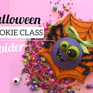 Puede incluir: Halloween Cookie Class: Spider. Una galleta decorada con forma de araña en una telaraña. La araña es morada con ojos verdes y una boca negra. La telaraña es naranja con líneas negras. La galleta está rodeada de chispas.