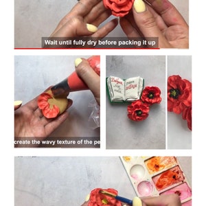 May include: A close-up of a hand holding a red felt poppy flower. The flower has a black center and is being painted with a brush. The background is a white surface with a watercolor palette.