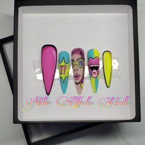 Może przedstawiać: Zestaw pięciu kolorowych sztucznych paznokci z różnymi wzorami w stylu pop art. Wzory obejmują różowy wykrzyknik i znak zapytania, twarz kobiety w okularach przeciwsłonecznych, różowy język wystający z ust i żółty paznokieć.