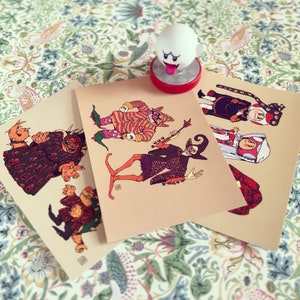 May include: Three illustrated cards featuring different characters in colorful costumes. The characters are a monster, a jester, and a wizard. The cards are printed on a beige background.