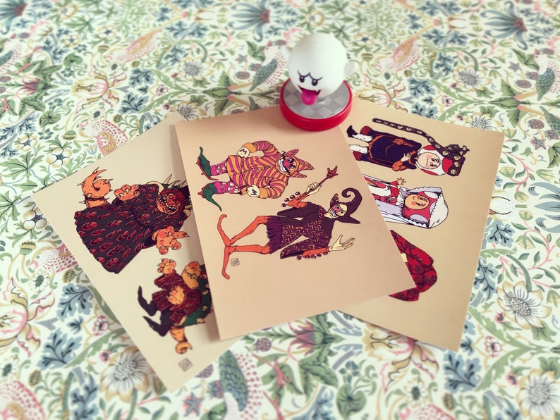 May include: Three illustrated cards featuring different characters in colorful costumes. The characters are a monster, a jester, and a wizard. The cards are printed on a beige background.