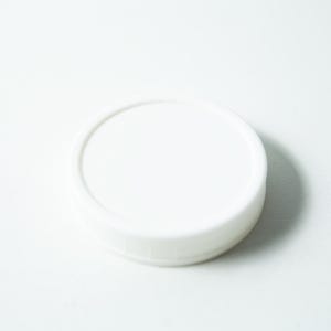 May include: A white plastic lid for a jar or container.