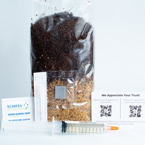 May include: A clear plastic bag filled with brown and yellow grains. A white card with the text "We Appreciate Your Trust!" and two QR codes is in the bottom right corner. A syringe, a small white package, and a business card with the text "Schiffa Health" are in the bottom left corner.