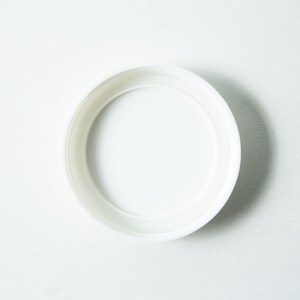 May include: A white plastic lid for a jar or container.